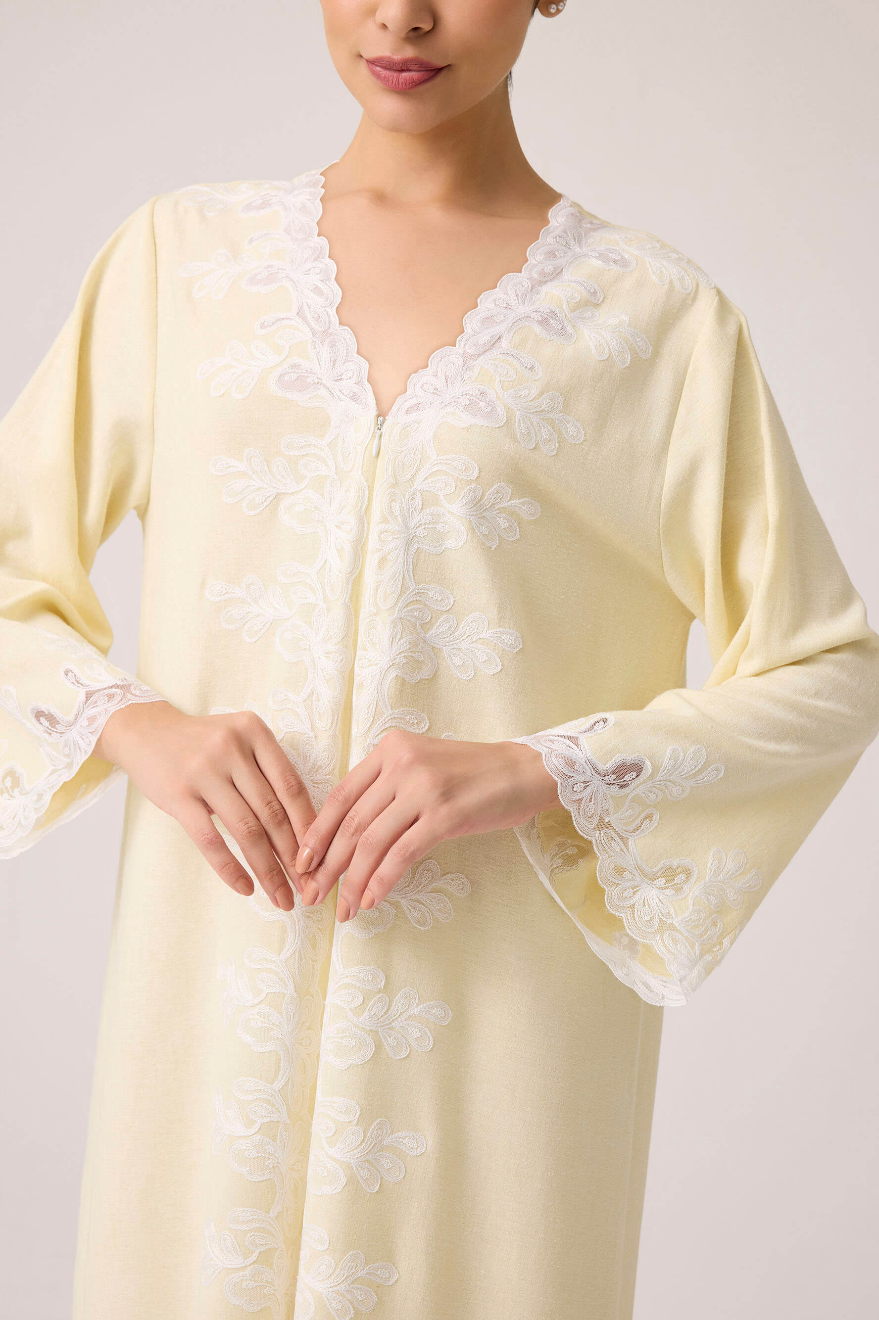 Light yellow robe with lace details on a plain background