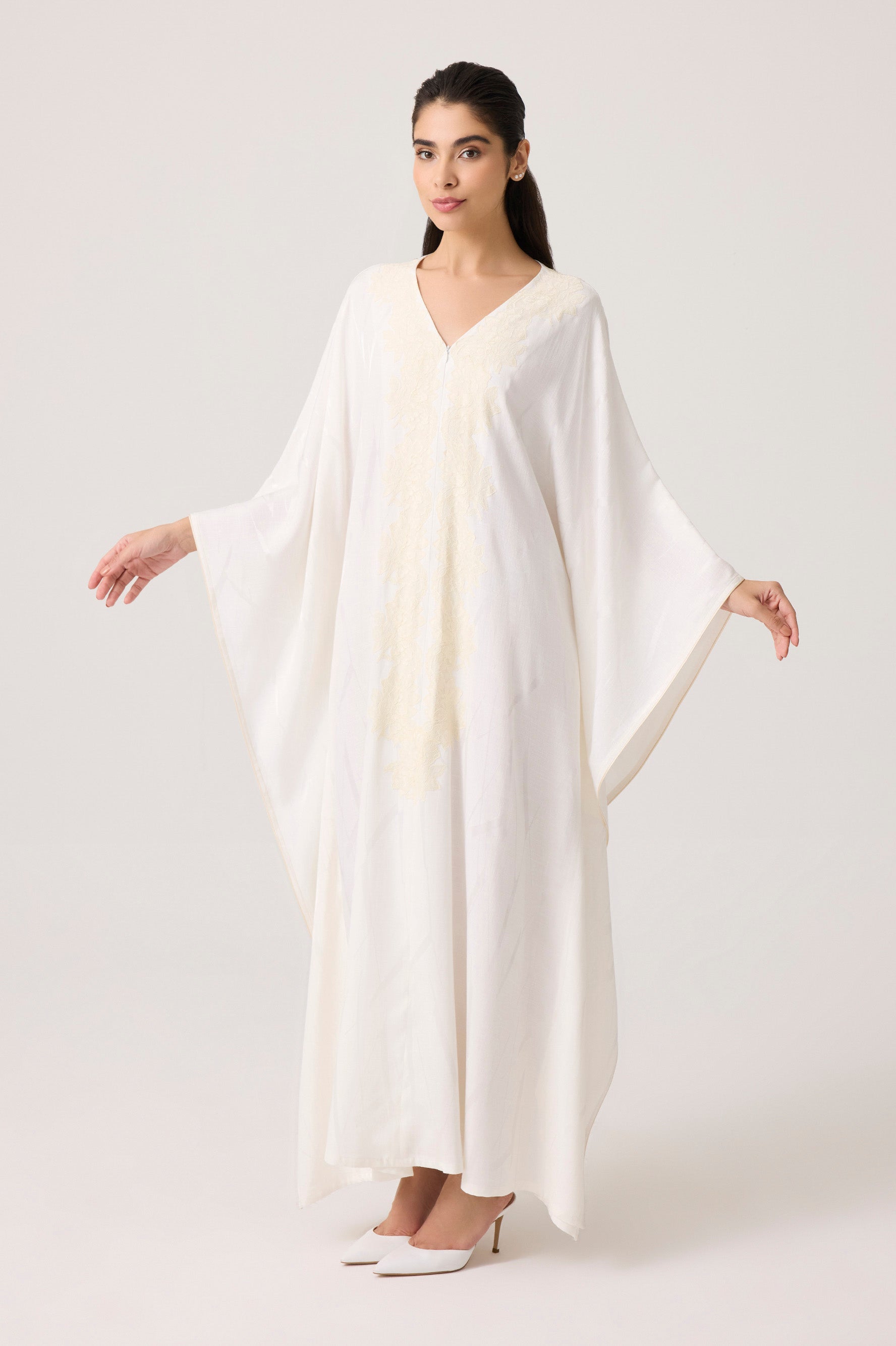 Woman wearing a white dress with a plain background