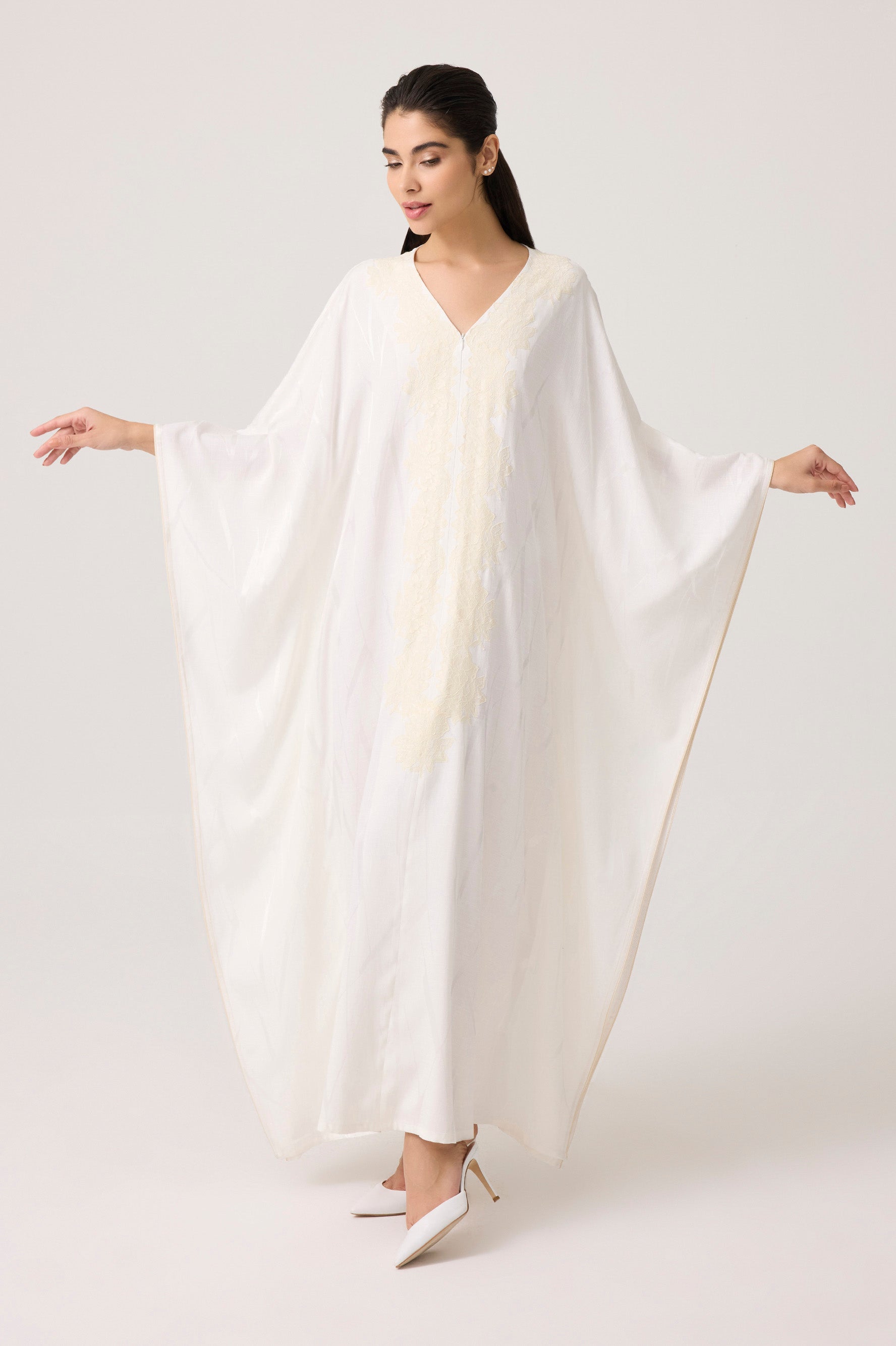 Woman wearing a white dress against a plain background