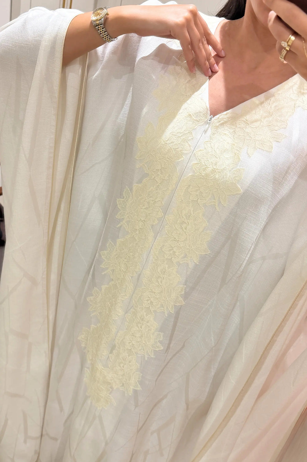 Close-up of a person wearing a white saree with a floral blouse.