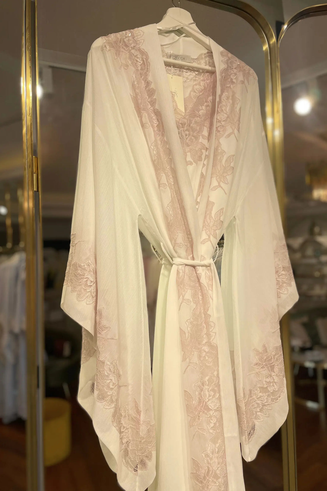 Beautiful lace robe hanging on a rack in a room by Bocan