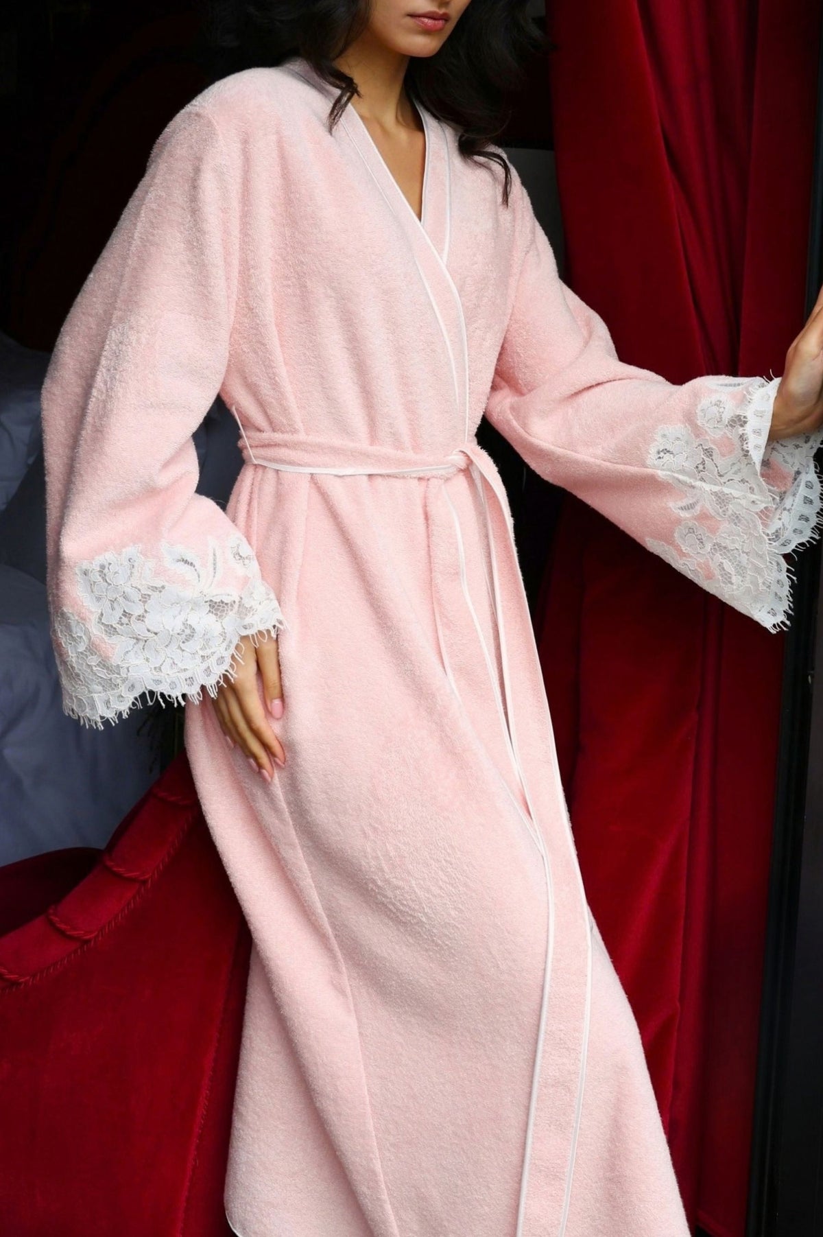 Model Woman wearing a pink bathrobe with white lace details by our new collection The Art of Her