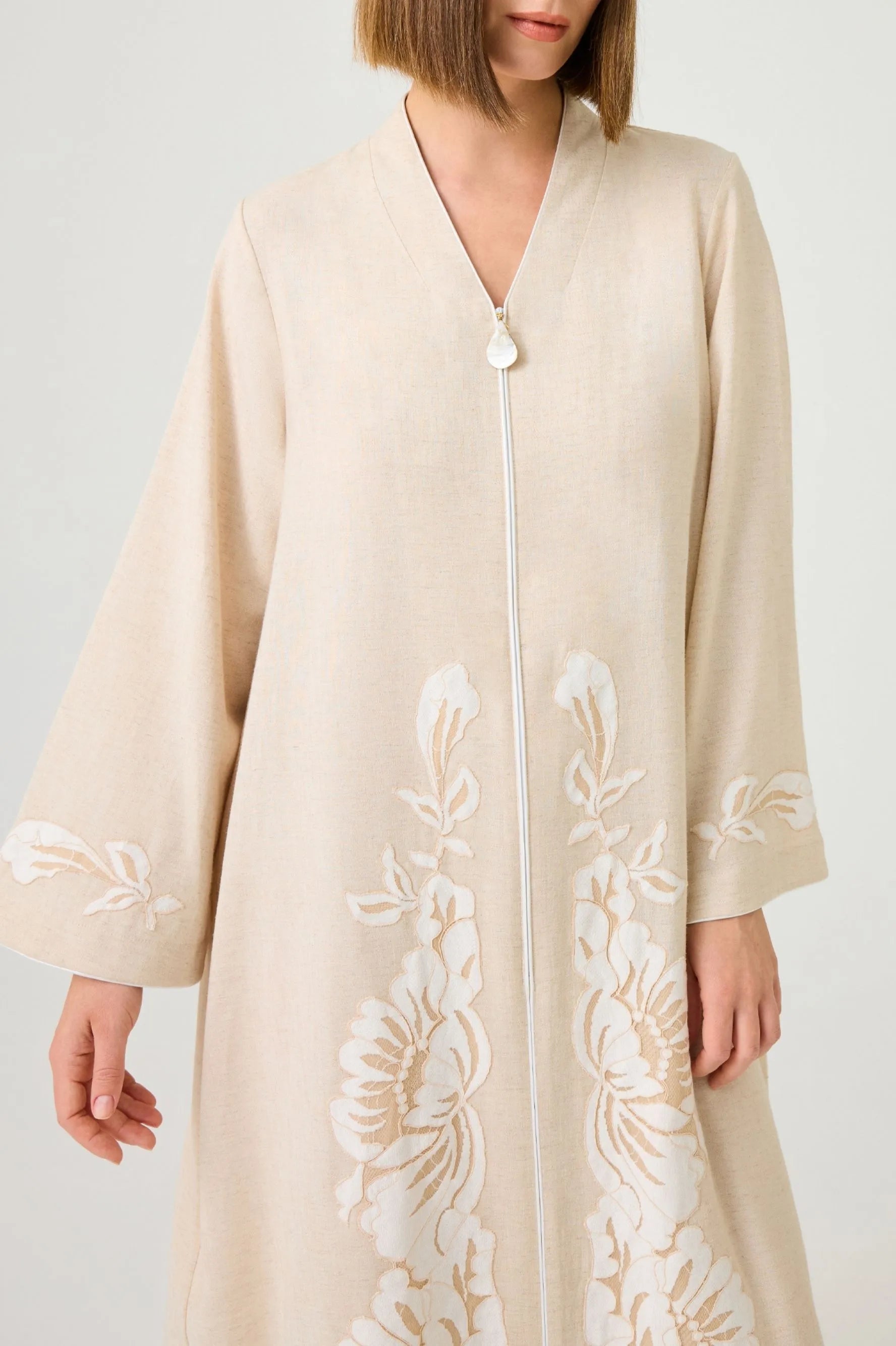 Beige kimono-style dress with white floral lace on a plain background