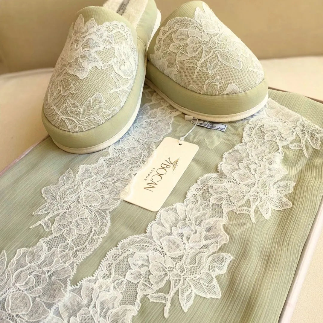Pair of green shoes with lace detailing on a wooden surface, accompanied by a 'Nook' tag.